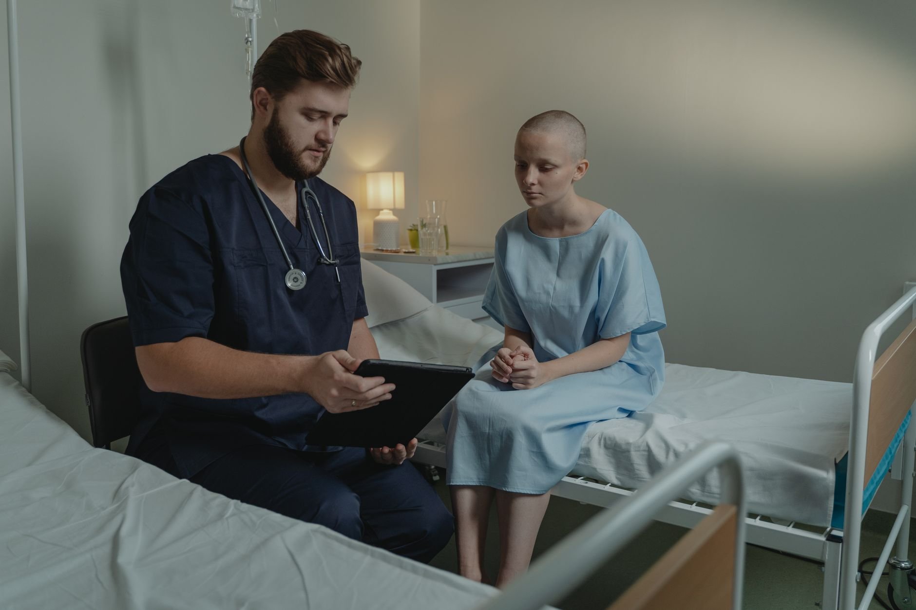 Soignant utilisant une tablette au chevet d'un patient dans un service hospitalier