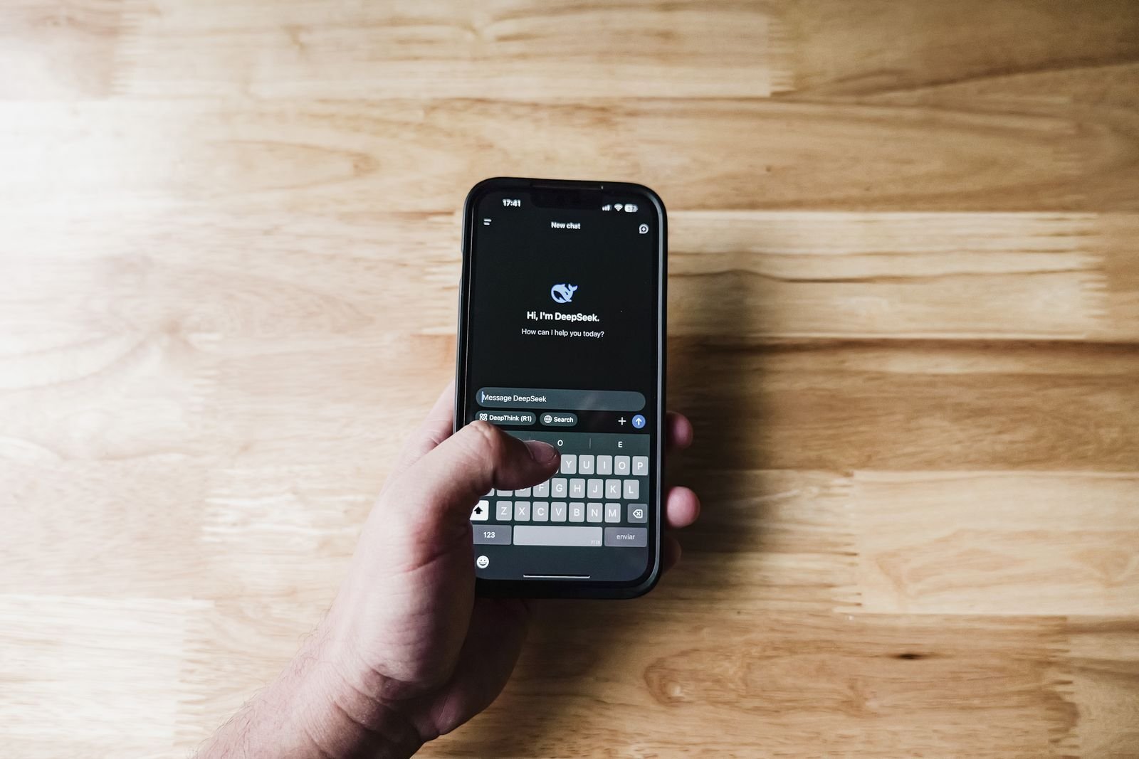 Main tenant un smartphone qui affiche un assistant d'IA générative