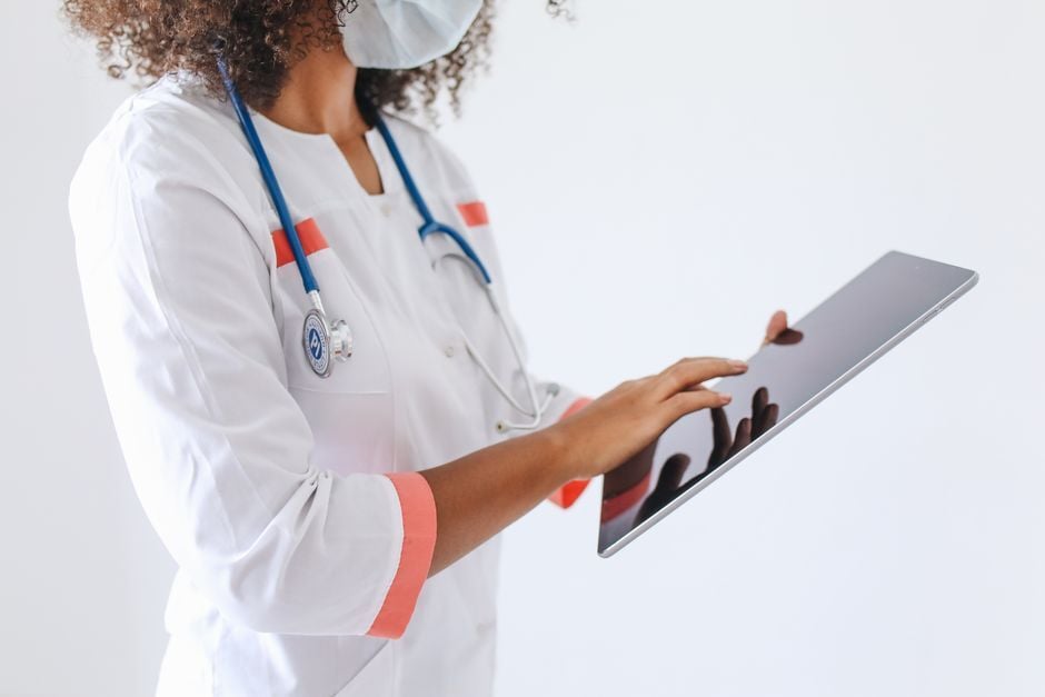 Clinical staff using a shared tablet on a hospital ward. Photo by Polina Tankilevitch on Pexels
