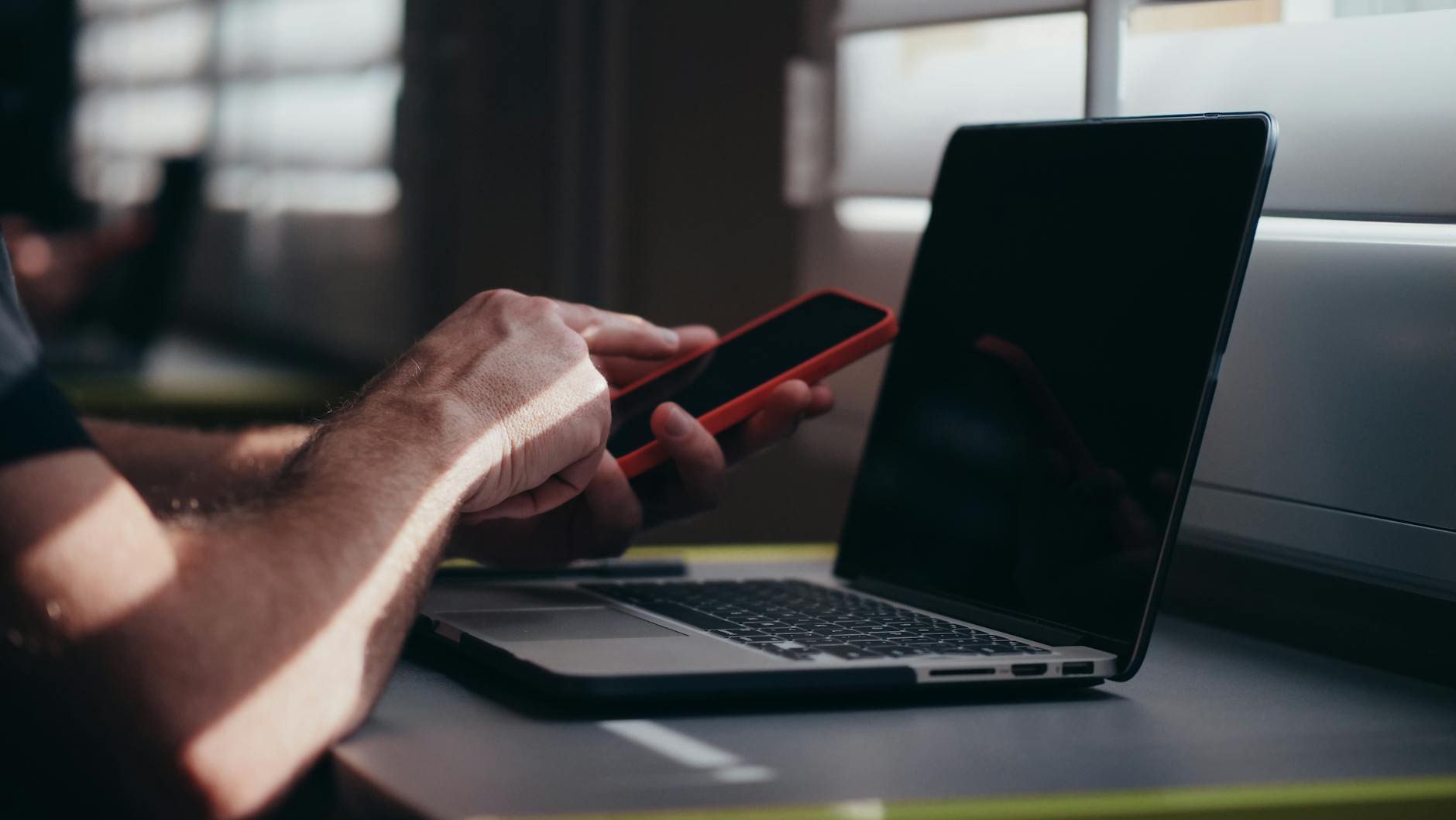 Laptop and smartphone on a desk, comparing MDM solutions (Photo by Kindel Media on Pexels)