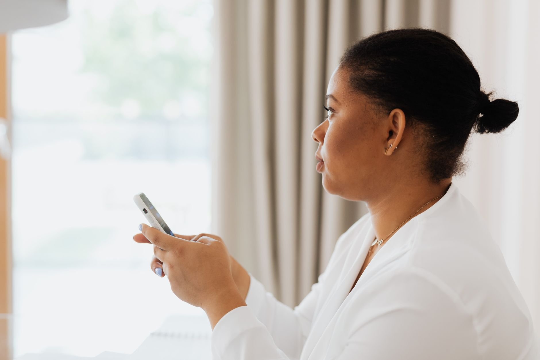 A professional woman using her smartphone indoors, focused on work.