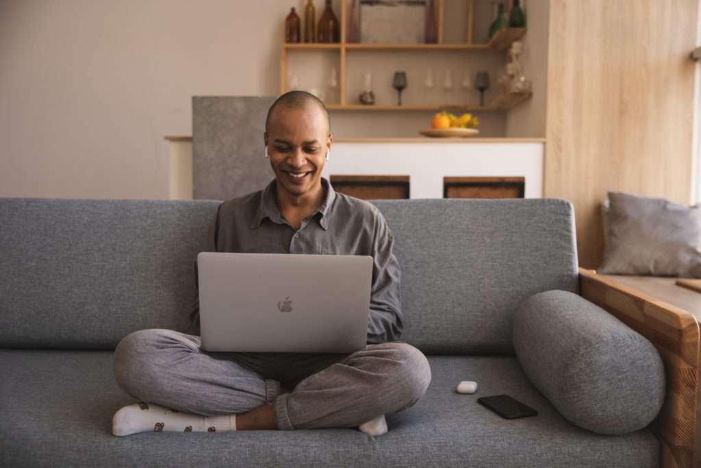 man using laptop on couch