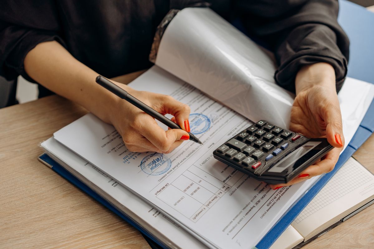 IT compliance audit documents on a desk. Photo by Mikhail Nilov on Pexels