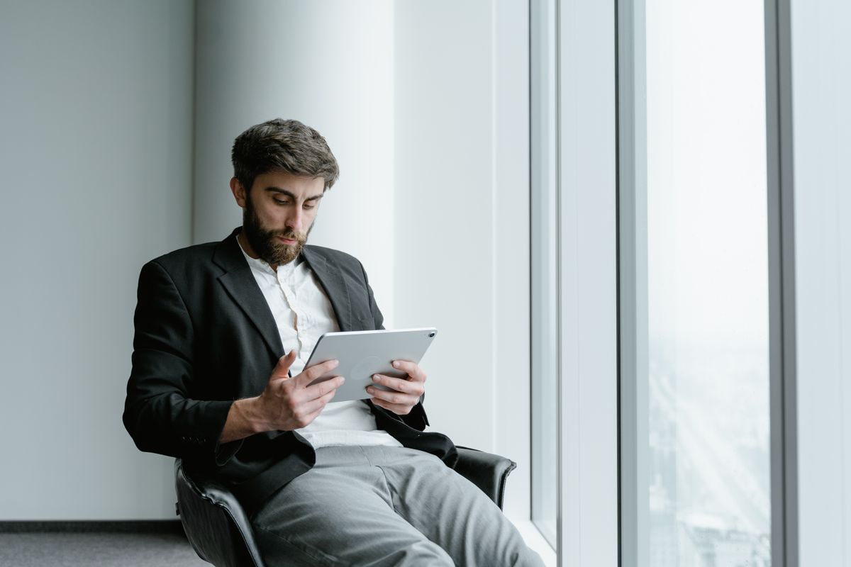 Professional using a tablet in an office setting. Photo by Tima Miroshnichenko on Pexels