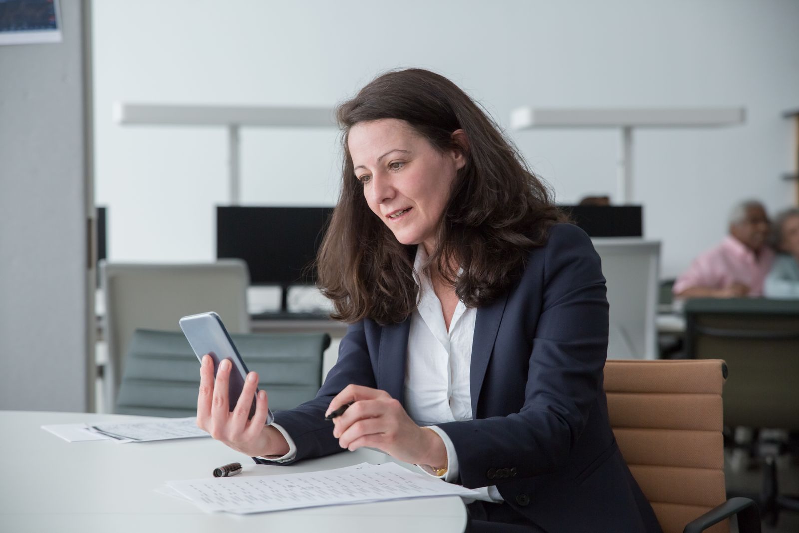 Salariée utilisant un smartphone à son bureau, le type d'appareil étudié par le Verizon Mobile Security Index 2025
