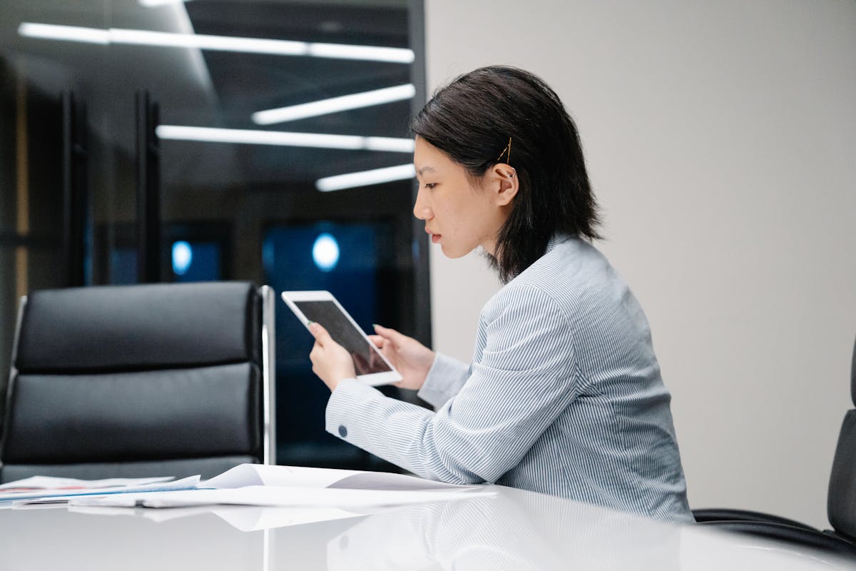 IT administrator managing mobile device updates on laptop (Photo by Felicity Tai on Pexels)