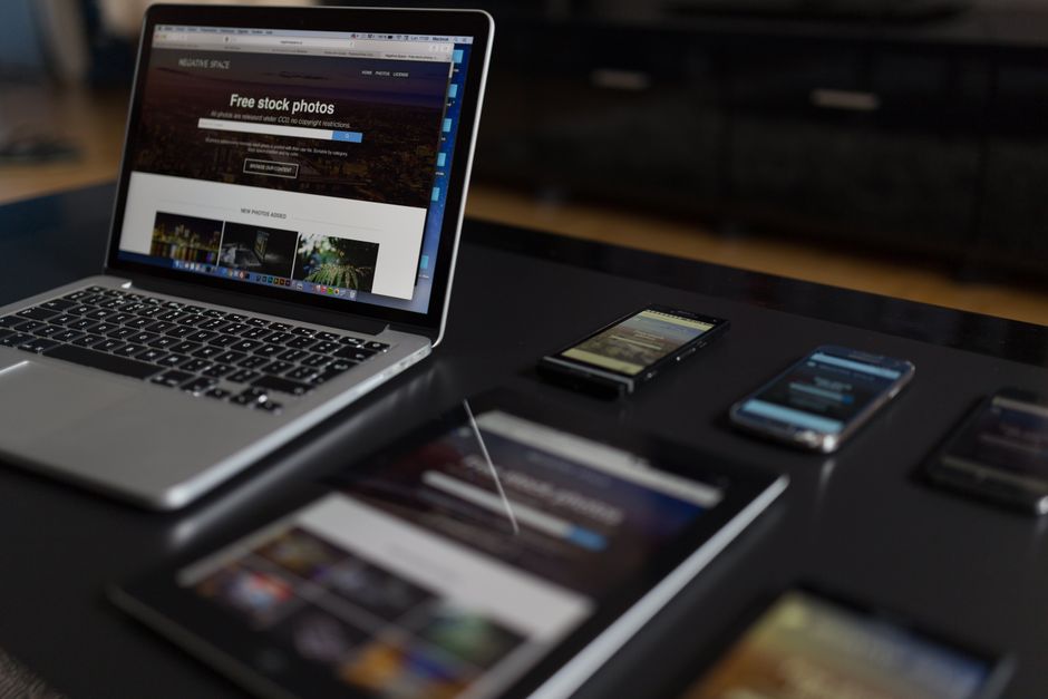 Laptop, smartphone and tablet on a desk, managed from one console