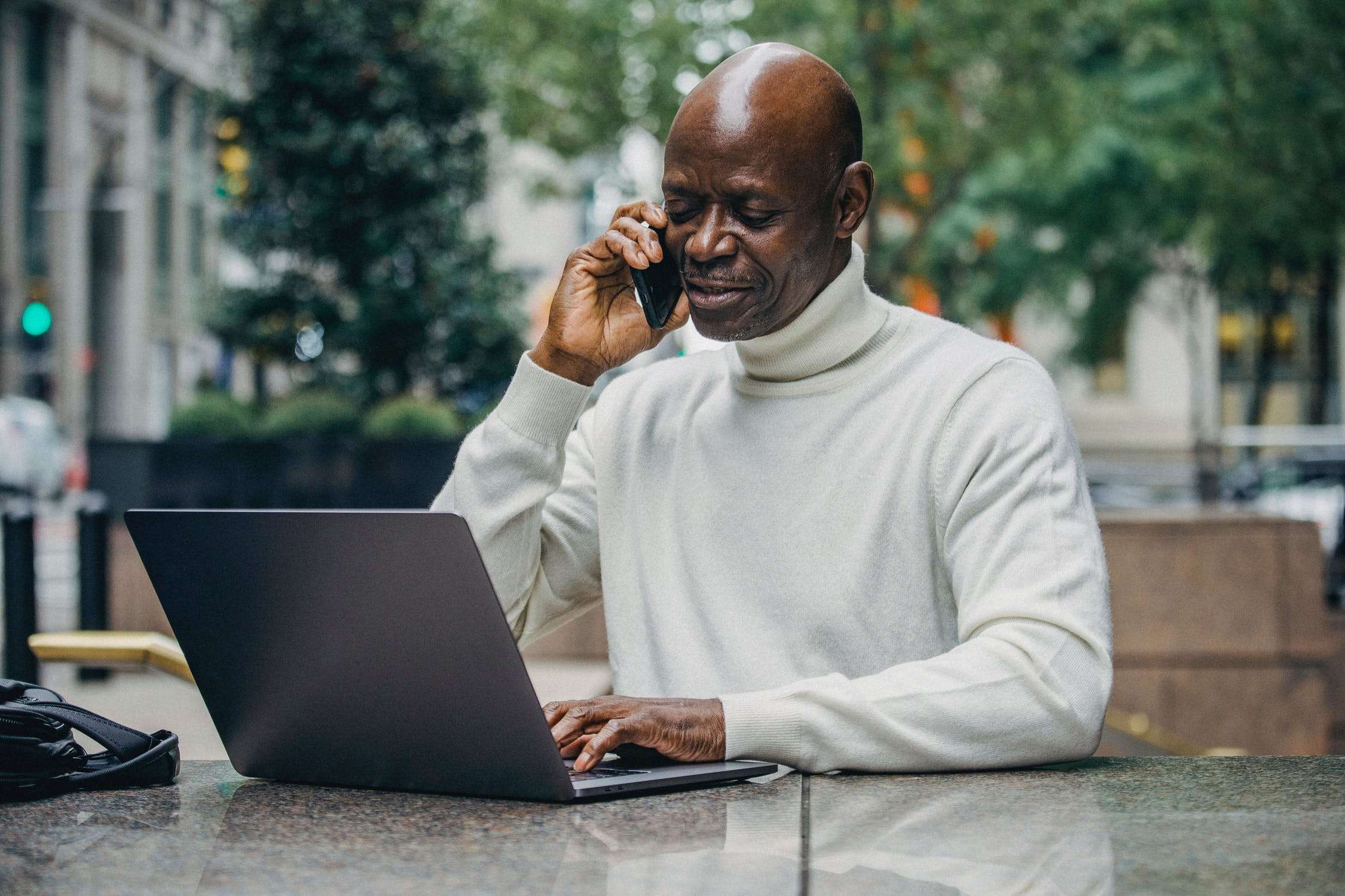 man working with phone and laptop